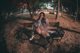 A woman sitting on a bench in a park at night.