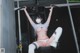 A woman wearing a face mask sitting on a bench in a gym.