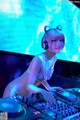 A woman in a bikini and headphones playing a dj set.