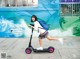 A young girl riding an electric scooter on a sidewalk.